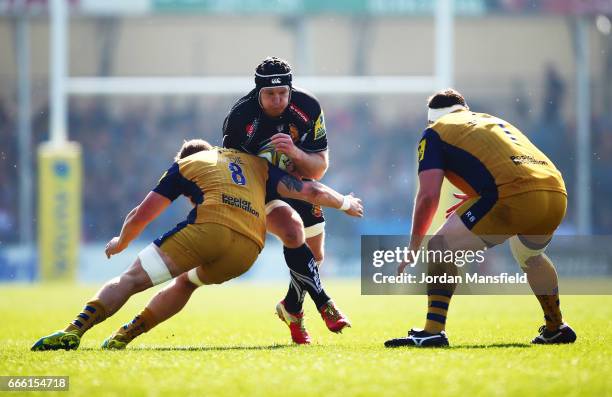 Thomas Waldrom of Exeter is tackled by Ross Harrison and Mitch Eadie of Bristol during the Aviva Premiership match between Exeter Chiefs and Bristol...