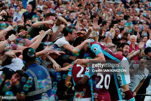West Ham players and fans celebrate the opening goal scored by West Ham United's Senegalese midfielder Cheikhou Kouyate during the English Premier...