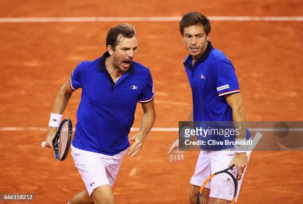 Julien Benneteau partnering Nicolas Mahut of France celebrate winning the third set in their doubles match against Jamie Murray and Dominic Inglot of...