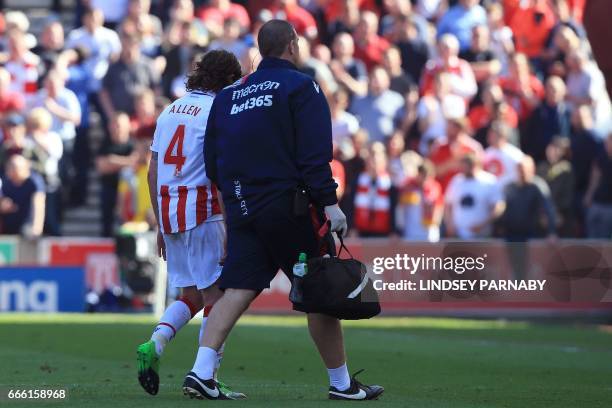 Stoke City's Welsh midfielder Joe Allen leaves the pitch injured following a challenge by Liverpool's Dutch midfielder Georginio Wijnaldum during the...