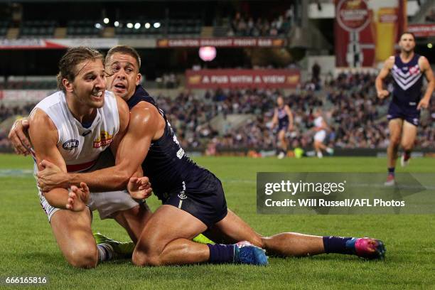 Marcus Bontempelli of the Bulldogs is tackled by Stephen Hill of the Dockers during the round three AFL match between the Fremantle Dockers and the...