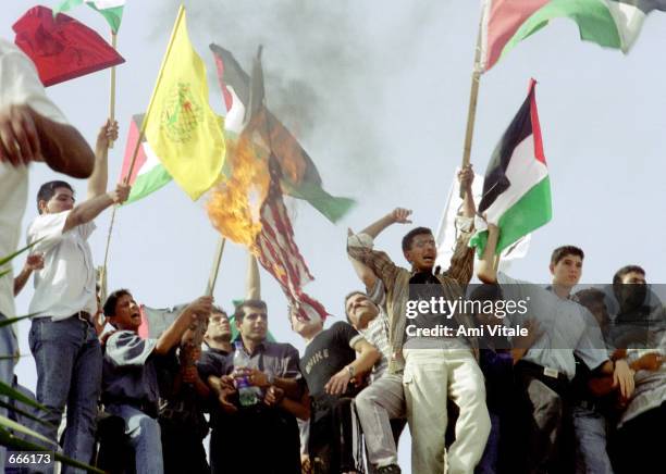 Palestinian protesters burn an American and an Israeli flag October 6, 2000 on top of a mosque in Gaza, Palestine. In the West Bank and Gaza,...