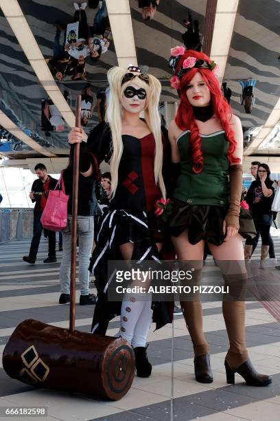 Cosplay enthusiasts dressed up as Harley Quinn caracter from the comic Suicide Squad and Poison Ivy comic caracter pose during the Romics event, a...