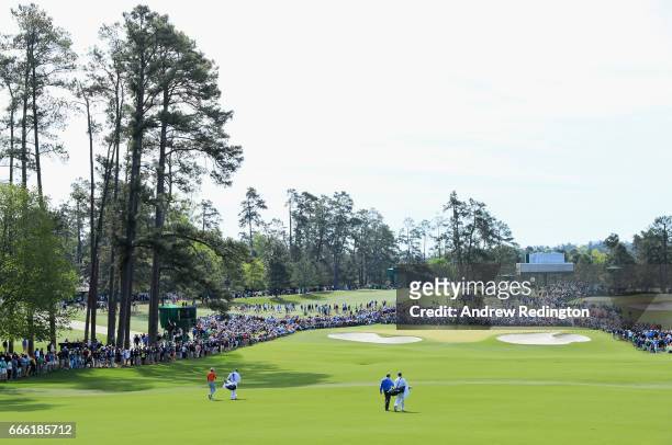 Jason Day of Australia and Augusta National member Jeff Knox , the noncompeting marker, approach the second green with their caddies during the third...