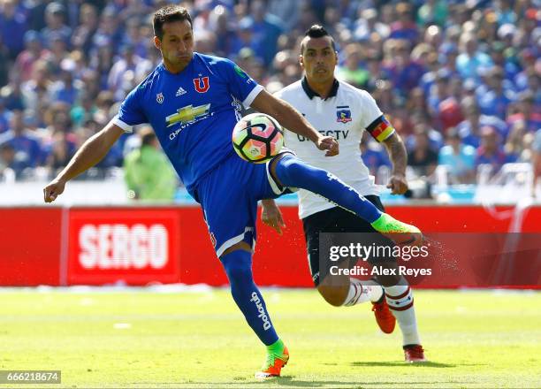 Christian Vilches of U De Chile fights for the ball with Esteban Paredes of Colo Colo during a match between U de Chile and Colo Colo as part of...