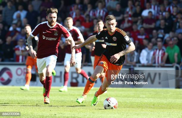 Jay O'Shea of Sheffield United moves forward with the ball away from Paul Anderson of Northampton Town during the Sky Bet League One match between...