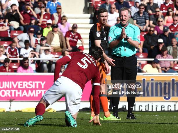 Referee Mark Heywood looks on as Zander Diamond of Northampton Town picks himself up being fouled by Jay O'Shea of Sheffield United during the Sky...