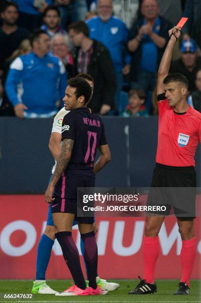 The referee shows a red card to Barcelona's Brazilian forward Neymar da Silva during the Spanish league football match Malaga CF vs FC Barcelona at...