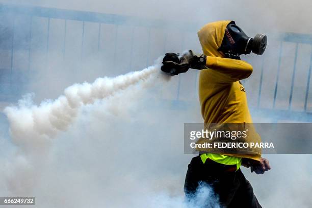 Riot police fire rubber bullets and tear gas grenades at demonstrators protesting against President Nicolas Maduro's government in Caracas on April...