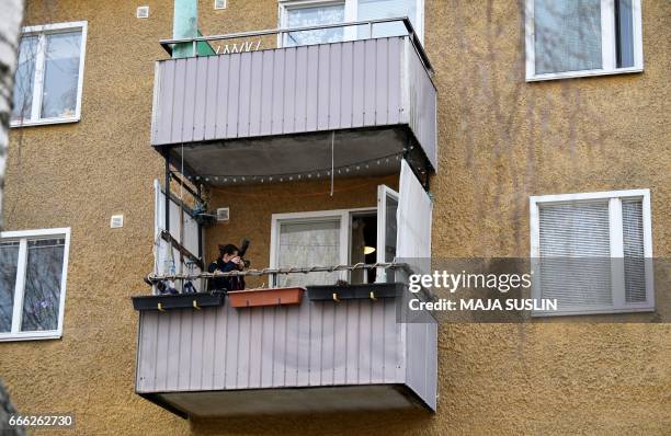 Police photographer takes pictures while police search an apartment in Varberg, south-west of Stockholm city on April 8 as part of an investigation...