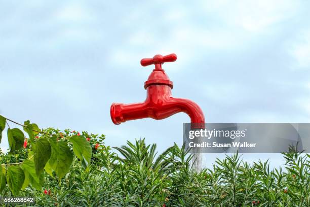 looking up to a large red flowing tap outdoors - drinkwaterfontein stockfoto's en -beelden