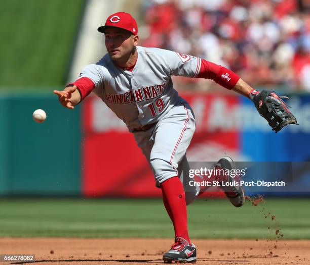 Cincinnati Reds first baseman Joey Votto flips the ball to the pitcher covering first on a ground out by the St. Louis Cardinals' Kolten Wong in the...