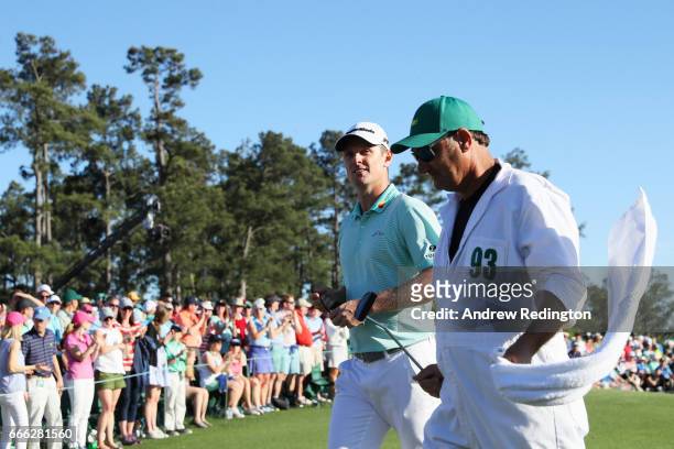 Justin Rose of England and caddie Mark Fulcher smile as they walk off the 18th green during the third round of the 2017 Masters Tournament at Augusta...