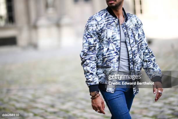 Theo Kimbaloula, fashion blogger, wears a Sand Copenhagen bomber jacket, an Asos t-shirt, Asos blue jeans, and Jules white sneakers shoes, at the...