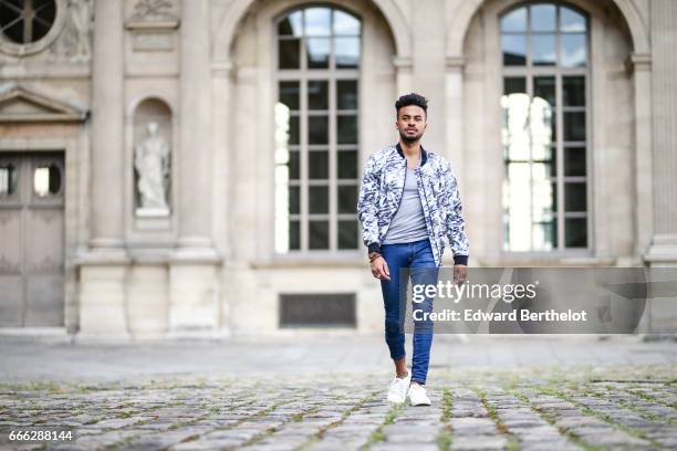 Theo Kimbaloula, fashion blogger, wears a Sand Copenhagen bomber jacket, an Asos t-shirt, Asos blue jeans, and Jules white sneakers shoes, at the...
