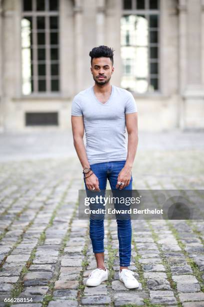 Theo Kimbaloula, fashion blogger, wears a Sand Copenhagen bomber jacket, an Asos t-shirt, Asos blue jeans, and Jules white sneakers shoes, at the...