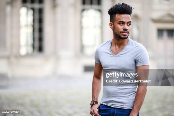 Theo Kimbaloula, fashion blogger, wears a Sand Copenhagen bomber jacket, an Asos t-shirt, Asos blue jeans, and Jules white sneakers shoes, at the...