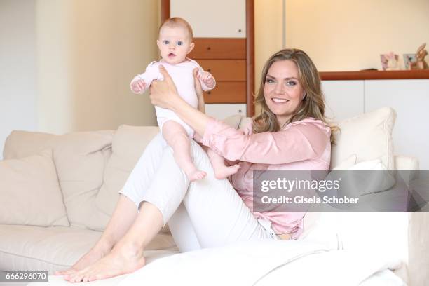 Julia Scharf, 'ARD Sportschau' sport moderator poses with her baby daughter Jonna during a photo session on April 3, 2017 in Munich, Germany.