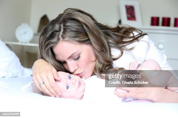 Julia Scharf, 'ARD Sportschau' sport moderator poses with her baby daughter Jonna during a photo session on April 3, 2017 in Munich, Germany.