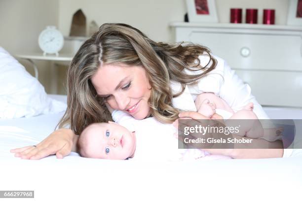 Julia Scharf, 'ARD Sportschau' sport moderator poses with her baby daughter Jonna during a photo session on April 3, 2017 in Munich, Germany.