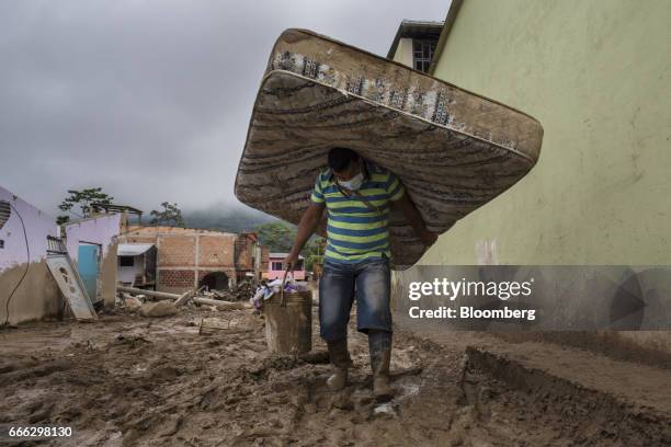Displaced resident carries a matteress and bucket of supplies after a landslide in the San Miguel neighborhood of Mocoa, Putumayo, Colombia, on...