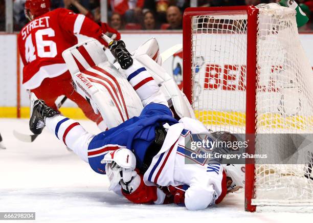 Alex Galchenyuk of the Montreal Canadiens crashes into Petr Mrazek of the Detroit Red Wings during the first period at Joe Louis Arena on April 8,...