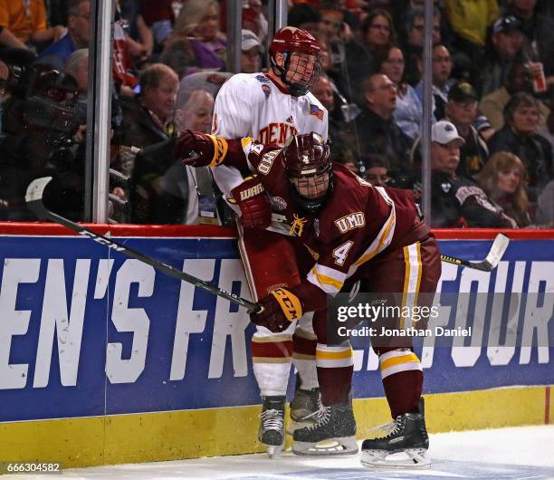 Neal Pionk of the Minnesota-Duluth Bulldogs checks Tariq Hammond of the Denver Pioneers into the boards during the 2017 NCAA Division I Men's Ice...