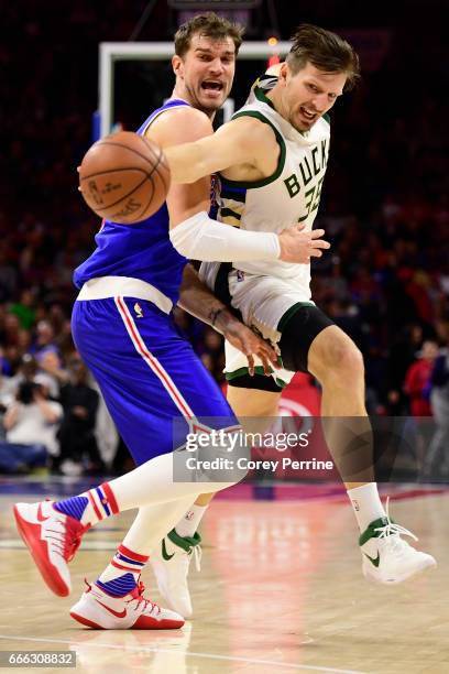 Tiago Splitter of the Philadelphia 76ers and Mirza Teletovic of the Milwaukee Bucks fight for a loose ball during the fourth quarter at the Wells...