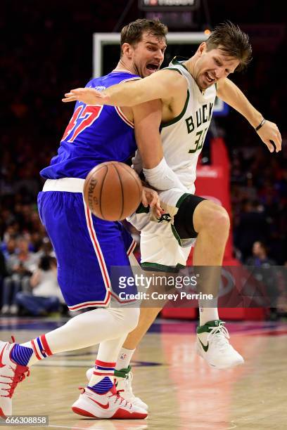 Tiago Splitter of the Philadelphia 76ers and Mirza Teletovic of the Milwaukee Bucks fight for a loose ball during the fourth quarter at the Wells...