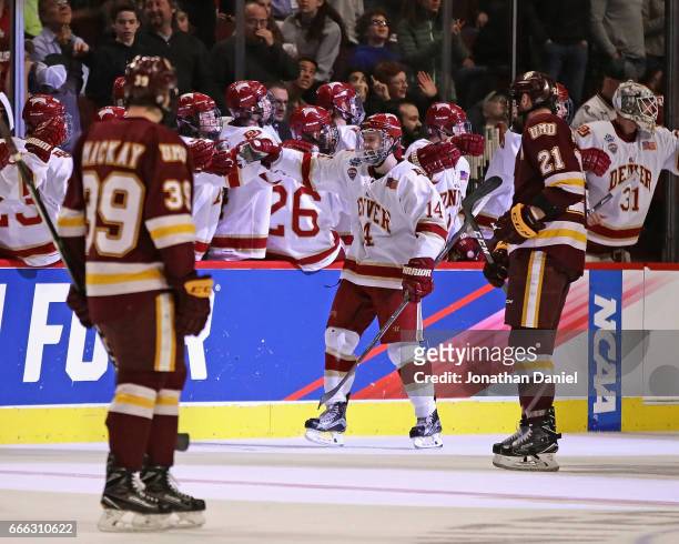 Jarid Lukosevicius of the Denver Pioneers is congratulated by teammates after scoring a hat trick in the second period against the Minnesota-Duluth...