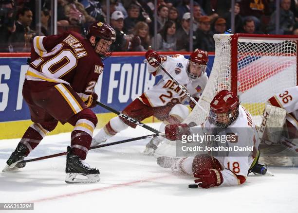 Emil Romig of the Denver Pioneers drops to the ice to block a shot by Karson Kuhlman of the Minnesota-Duluth Bulldogs during the 2017 NCAA Division I...