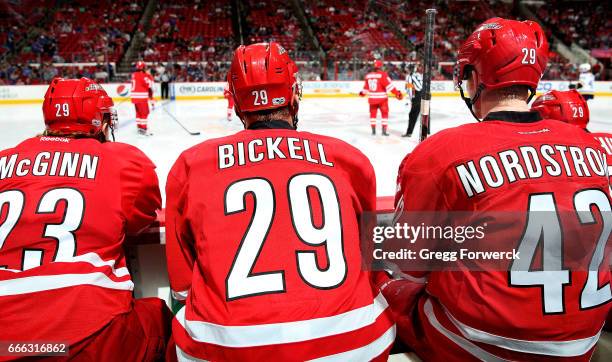 Brock McGinn of the Carolina Hurricanes and teammate Joakim Nordstrom each don the on their helmets to honor Bryan Bickell during an NHL game against...