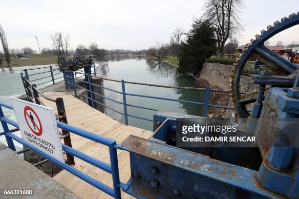 Picture taken on February 22, 2017 shows a placard reading "Except at your own risk" on a small hydro plant on the Korana river, in Karlovac,...