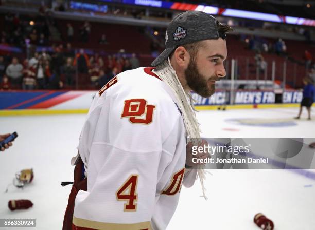 Will Butcher of the Denver Pioneers wears a peice of the net around his neck following a win over Minnesota-Duluth Bulldogs during the 2017 NCAA...