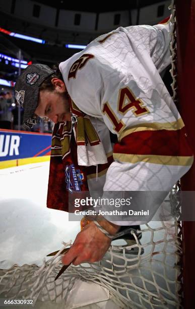 Jarid Lukosevicius of the Denver Pioneers cuts a piece of the net follwoing a win over the Minnesota-Duluth Bulldogs during the 2017 NCAA Division I...