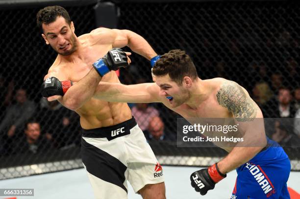 Chris Weidman lands a punch on Gegard Mousasi of the Netherlands in their middleweight bout during the UFC 210 event at KeyBank Center on April 8,...