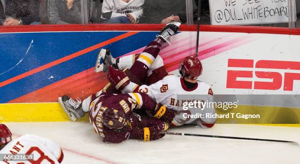 Tariq Hammond of the Denver Pioneers and Jared Thomas of the Minnesota Duluth Bulldogs crash into the boards during the 2017 NCAA Division I Men's...