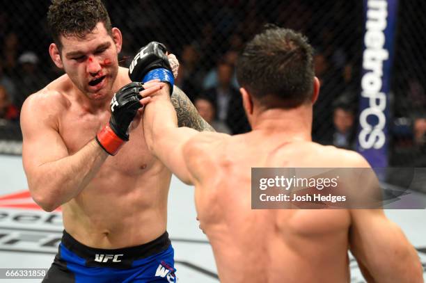 Gegard Mousasi of the Netherlands lands a punch on Chris Weidman in their middleweight bout during the UFC 210 event at KeyBank Center on April 8,...