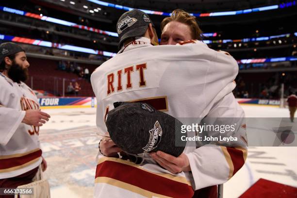 Denver Pioneers forward Evan Ritt gives a hugs to Denver Pioneers defenseman Tariq Hammond after their win over the Minnesota-Duluth Bulldogs 3-2 in...