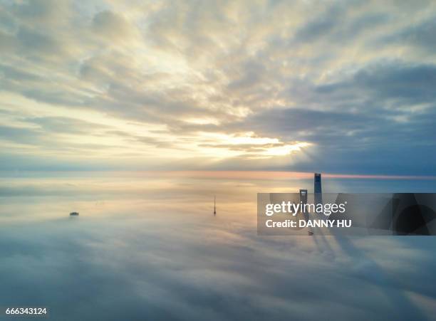 skyscrapers in fog - skyscraper cloud stock pictures, royalty-free photos & images