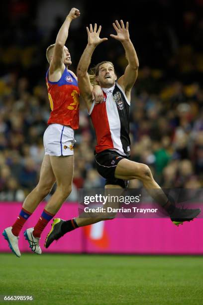 Josh Bruce of the Saints marks the ball in front of Jack Frost of the Lions during the round three AFL match between the St Kilda Saints and the...