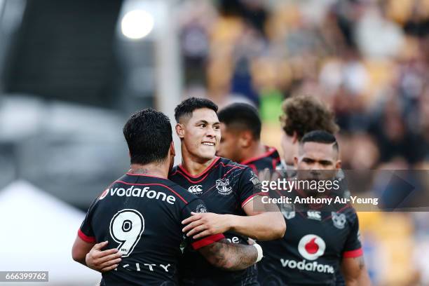 Roger Tuivasa-Sheck of the Warriors celebrates with teammate Issac Luke after Ken Maumalo's try during the round six NRL match between the New...