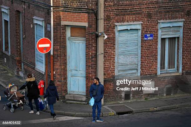 People make their way down a street of terraced houses on February 15, 2017 in Henin Beaumont, France. The former mining town in northern France,...