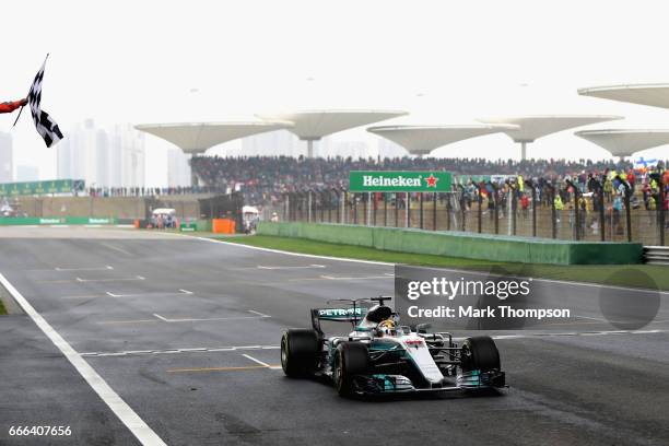 Lewis Hamilton of Great Britain driving the Mercedes AMG Petronas F1 Team Mercedes F1 WO8 takes the chequered flag and the win during the Formula One...