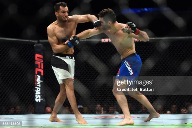 Gegard Mousasi of the Netherlands punches Chris Weidman in their middleweight bout during the UFC 210 event at the KeyBank Center on April 8, 2017 in...