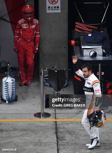 McLaren's Spanish driver Fernando Alonso walks through the pit lane after retiring from the Formula One Chinese Grand Prix in Shanghai on April 9,...