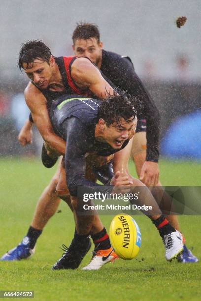 Jack Silvagni of the Blues handballs away from Mark Baguley of the Bombers during the round three AFL match between the Carlton Blues and the...