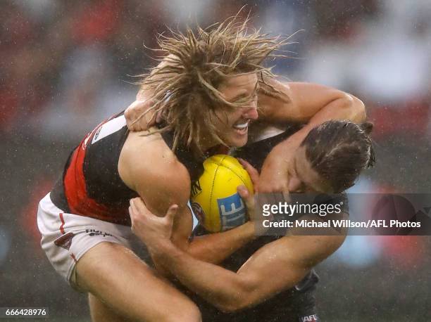 Dyson Heppell of the Bombers is tackled by Bryce Gibbs of the Blues during the 2017 AFL round 03 match between the Carlton Blues and the Essendon...