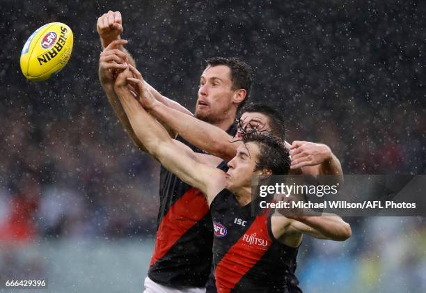 Matthew Leuenberger of the Bombers, Matthew Kreuzer of the Blues and Andrew McGrath of the Bombers compete for the ball during the 2017 AFL round 03...