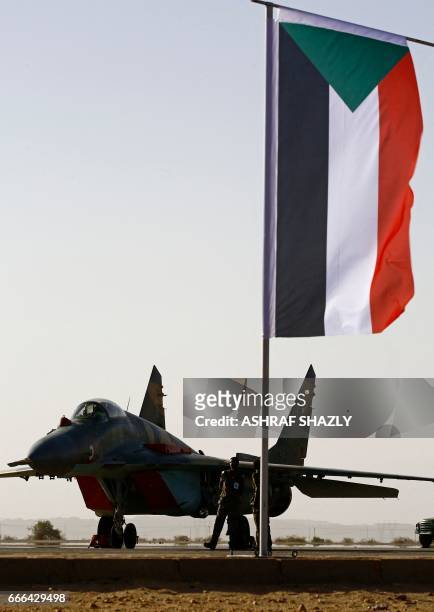 Plane sits on the tarmac next to a Sudanese flag during a joint Sudan and Saudi Arabia air force drill at the Marwa air base, near Meroe some 350...